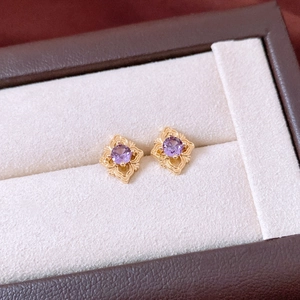 Vue macro détaillée de boucles d'oreilles en zircon violet avec filigrane doré vintage