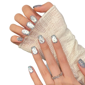 Starry sky style press-on nails with silver glitter and blue polka dots on hands
