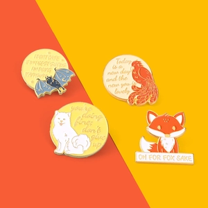 Détail de quatre épingles en émail colorées avec citations sur fond bicolore