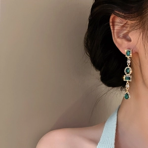 Boucles d'oreilles vintage en émeraude avec cristaux portées par un mannequin