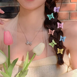 Colorful mini butterfly hair clips worn on braided hair for a sweet and fresh look