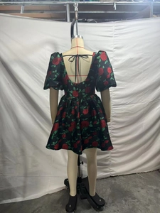 Détail d'une robe noire à fleurs avec roses rouges et dos nu noué élégant