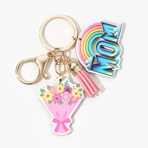 Detailed view of gold MOM keychain with rainbow acrylic charm, floral tag and pink tassel