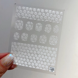 Makroansicht der weißen 5D geprägten Kirschblüten-Nagelsticker mit hohlen Blumenmustern