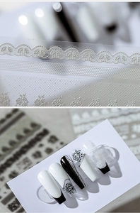 Macro view of white lace floral nail stickers with intricate 3D hollow patterns
