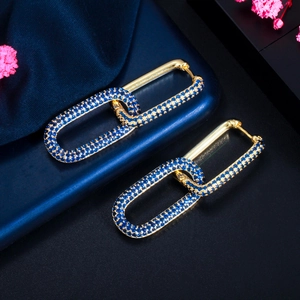Detailed macro view of 18K gold plated clasp earrings featuring deep blue zircon stones