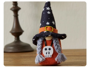 Close-up of Halloween gnome with black star hat and skull charm on wooden surface