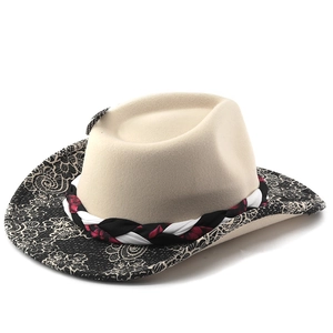 Detail of beige felt cowboy hat with black floral lace brim and colorful braided band