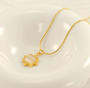 Détail d'un collier chaîne serpent doré avec un pendentif carré en pierre de lune
