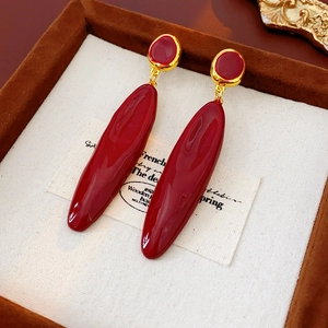 Détail de boucles d'oreilles pendantes bordeaux style rétro sur velours brun