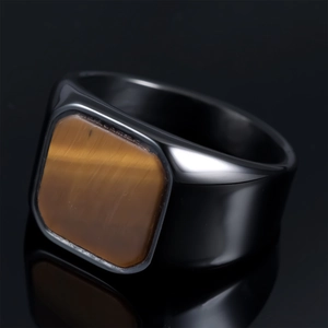 Macro detail of men's black square ring featuring a brown tiger eye stone inlay