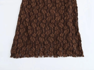 Close-up detail of the brown lace hollow pattern and textured fabric on the dress