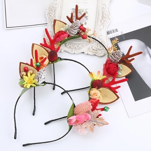 Detailed view of Christmas antler headbands with red berries and festive pine cones