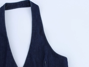 Gros plan sur le décolleté licou et les surpiqûres d'une robe d'été en jean bleu foncé