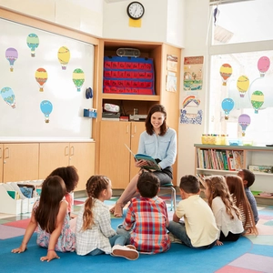Classroom scene with colorful hot air balloon cutouts and alphabet pocket chart on a wall