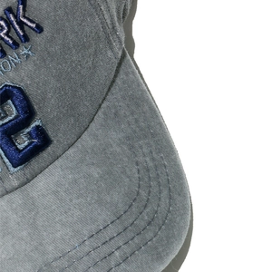 Macro detail of 3D embroidery and washed cotton fabric texture on a vintage baseball cap