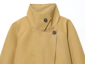Close-up of khaki trench coat collar with button detail and twill fabric texture