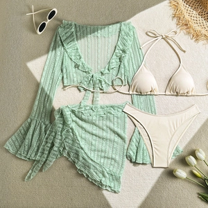 Flat lay of a 4-piece lace bikini set with green floral cover-up and resort accessories