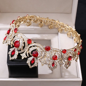 Vintage golden bridal crown with red gems and sparkling rhinestones on a display box