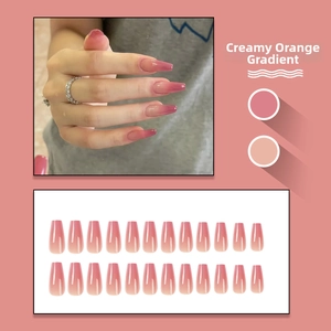 Detail of long ballerina nails with creamy orange-red gradient and glossy finish