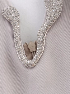 Macro shot of heavy-duty rhinestone inlay and tonal zipper with embossed metal slider