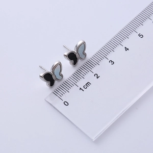 Macro shot of butterfly titanium steel earrings showing size measurement of 1.2cm