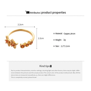 Detailed view of 18k gold plated butterfly open ring with orange zircon and copper specs