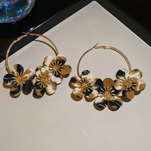Detail of leopard print fabric flowers on gold hoop earrings with ethnic retro design