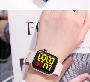 Detail of beige silicone band and square black LED watch on wrist with heart icon