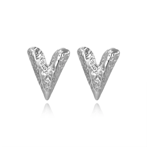 Macro detail of silver heart stud earrings with handcrafted hammered metal texture finish