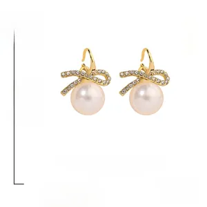 Detail showing bowknot earrings with faux pearls and dimensions 2.5cm by 1.8cm