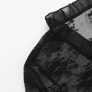 Gros plan sur tissu en dentelle florale noire avec mesh transparent et bords plissés