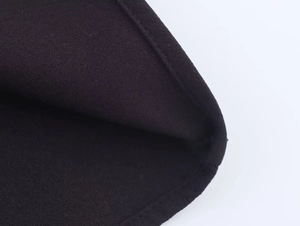 Detailopname van de zwarte gebreide textuur en hoogwaardige stiksels van de jurk