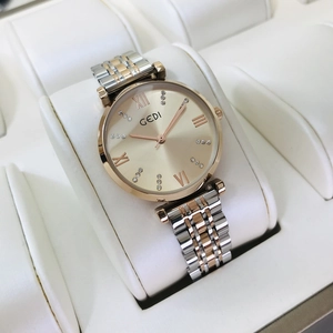 Detail of GEDI gold and silver steel watch band with rhinestone dial on display pillow