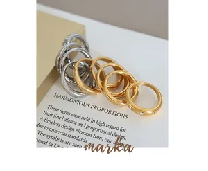 Detail of minimalist gold and silver stainless steel rings with zircon on magazine backdrop