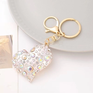 Detail of heart keychain with sparkling clear and iridescent rhinestones on gold metal