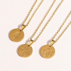 Three gold oval titanium steel necklaces with engraved floral patterns on white background