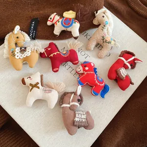 Detailed close-up of handmade fabric horse brooches with floral embroidery and sequins