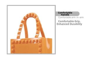 Detail view of the orange PVC tote bag showing the comfortable reinforced handle and studs