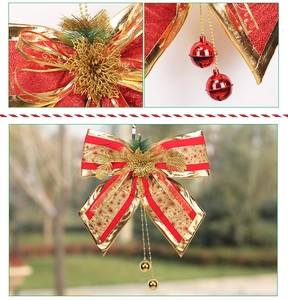 Detail of red and gold Christmas bow with bell ornaments and pine needle accents