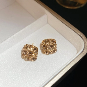Close-up of vintage champagne gold plated square stud earrings with faceted crystals