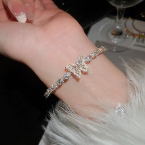 Dettaglio dell'elegante bracciale a farfalla dorato con cristalli di zircone lucidi