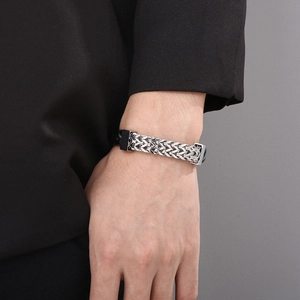 Close-up of double-row woven stainless steel bracelet with black magnetic buckle on wrist