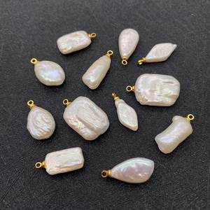 Macro shot of irregular baroque freshwater pearls with lustrous white finish and gold loops