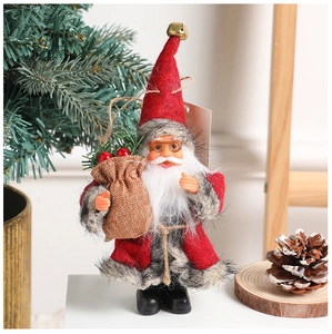 Close-up of a Christmas gnome doll with red knitted hat, grey robe, and a small gift bag