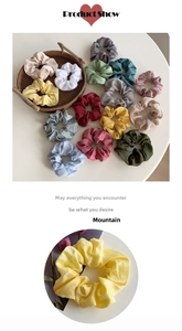 Close-up of colorful satin silk scrunchies set in a rustic woven tray on a white surface