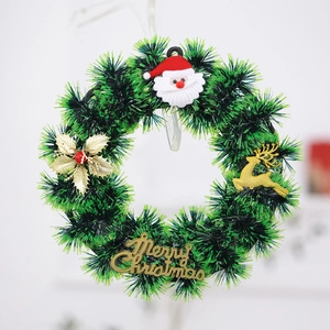Artificial green Christmas wreath with golden reindeer and Santa Claus ornament
