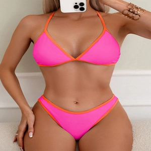 Front view of neon pink bikini set with orange piping trim worn by a model