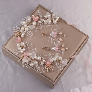 Detail von floralem Haarbands-Set mit rosa matten Blumen und weißen Perlen auf Box