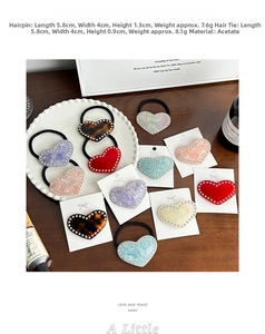 Detail of acetate heart hair clip and hair tie set with sparkling crystal rhinestones